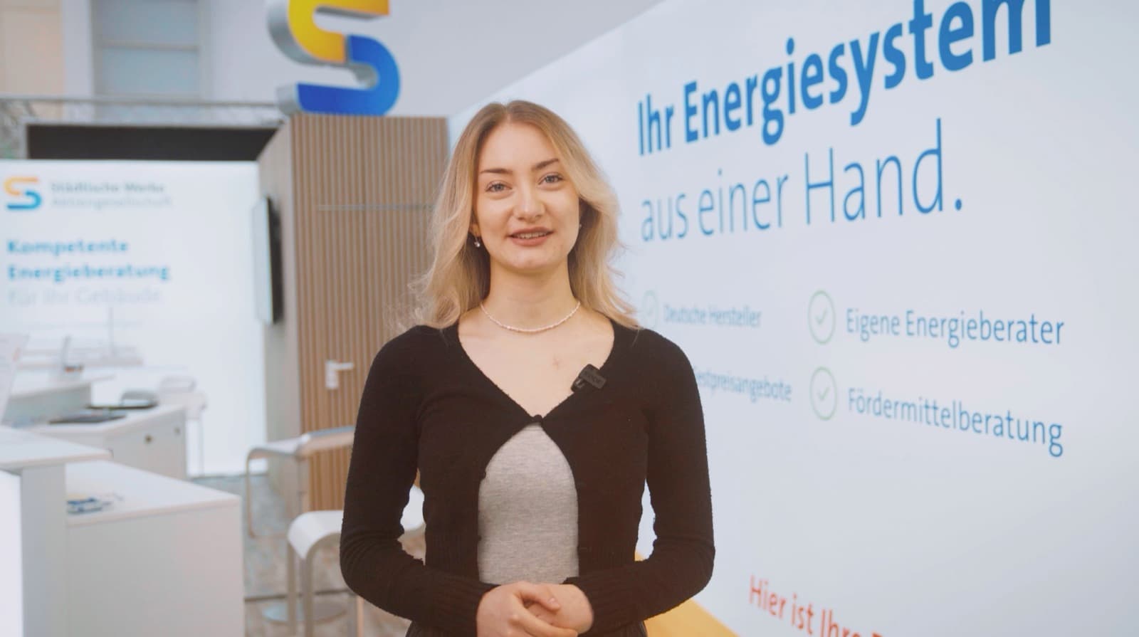 ANRELO-Sprecherin am Messestand der Städtischen Werke vor der Wand mit dem Slogan „Ihr Energiesystem aus einer Hand“